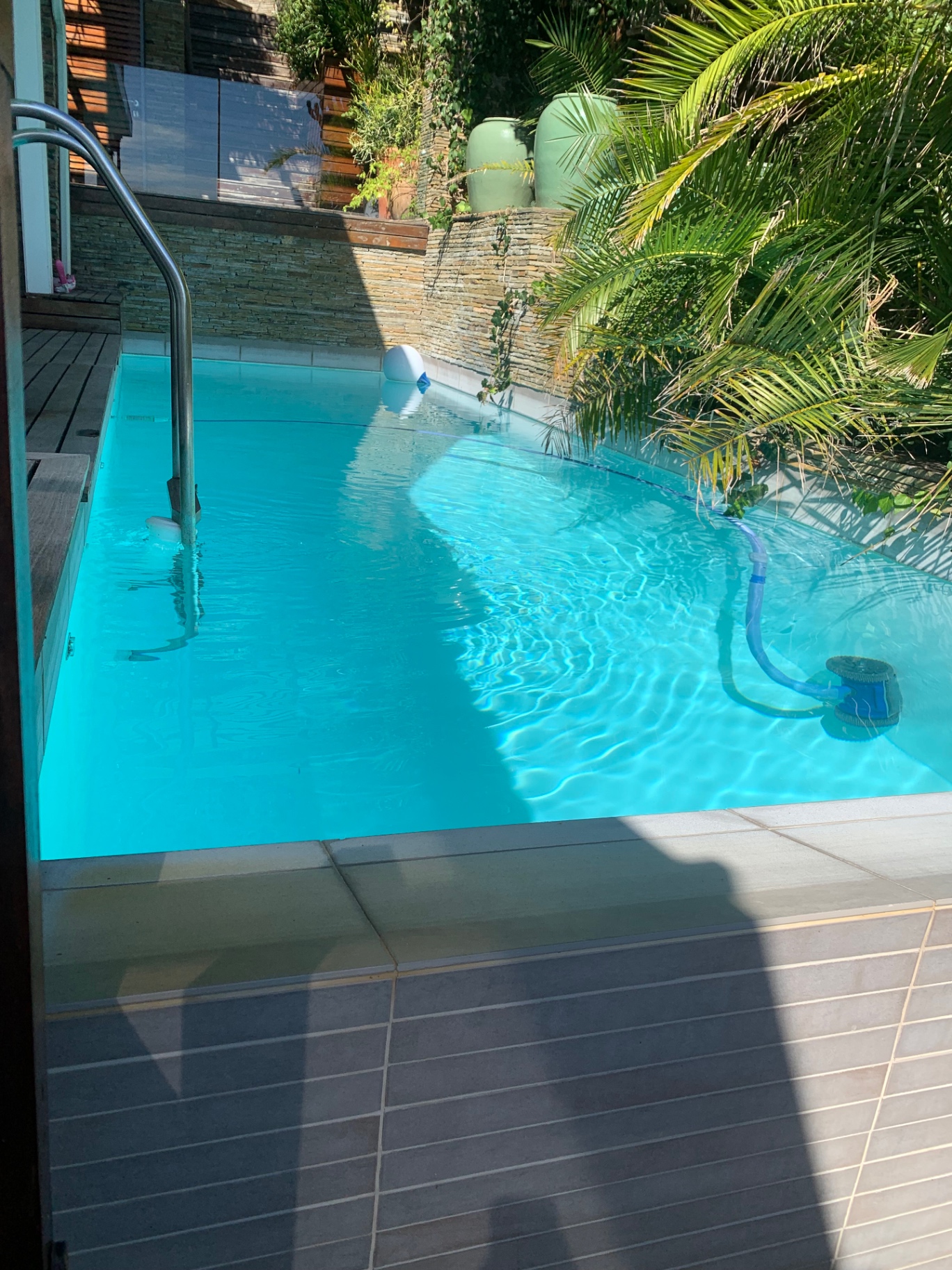 Clean turquoise pool with a pool cleaner running along the floor
